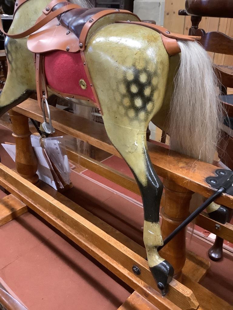 A 1920's F.H. Ayres painted wood rocking horse, on a trestle stand, fully restored in 2009 by Stevenson Bros., length 112cm height 100cm